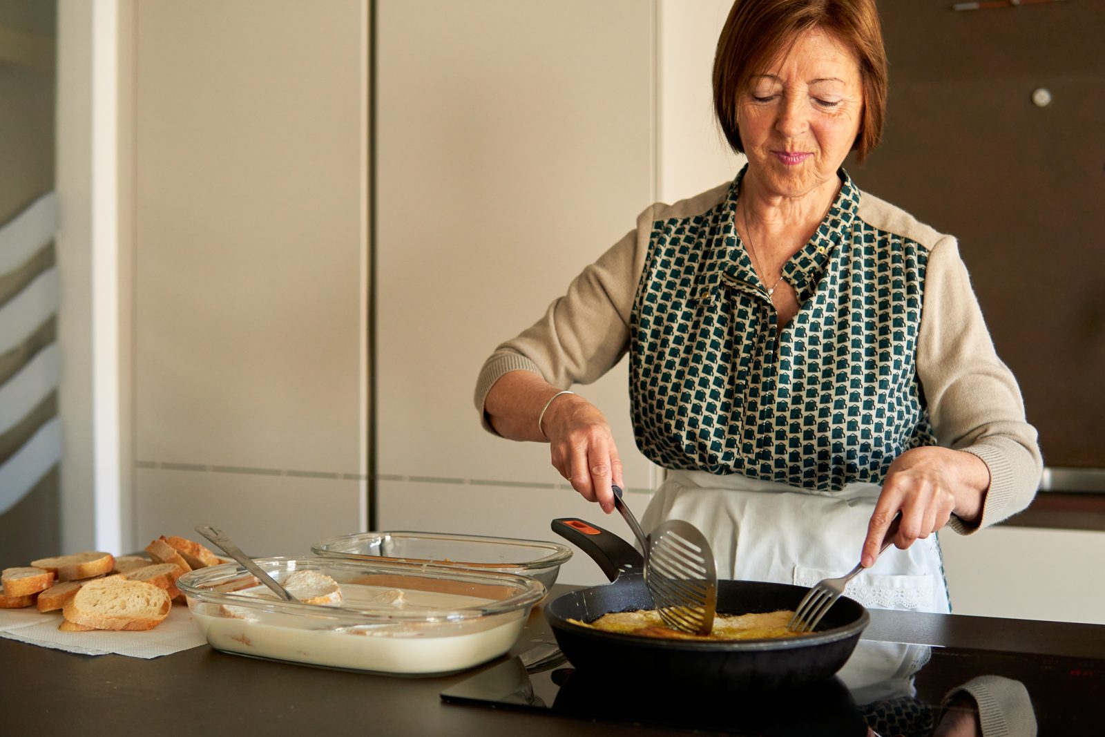 Mujer cocinando con tranquilidad y seguridad en su cocina de inducción